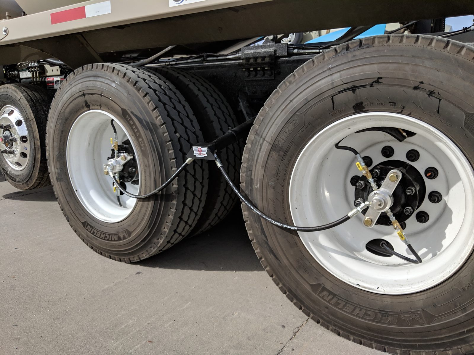 AirDown wheel-end valves and hoses on a concrete mixer's rear dual tires