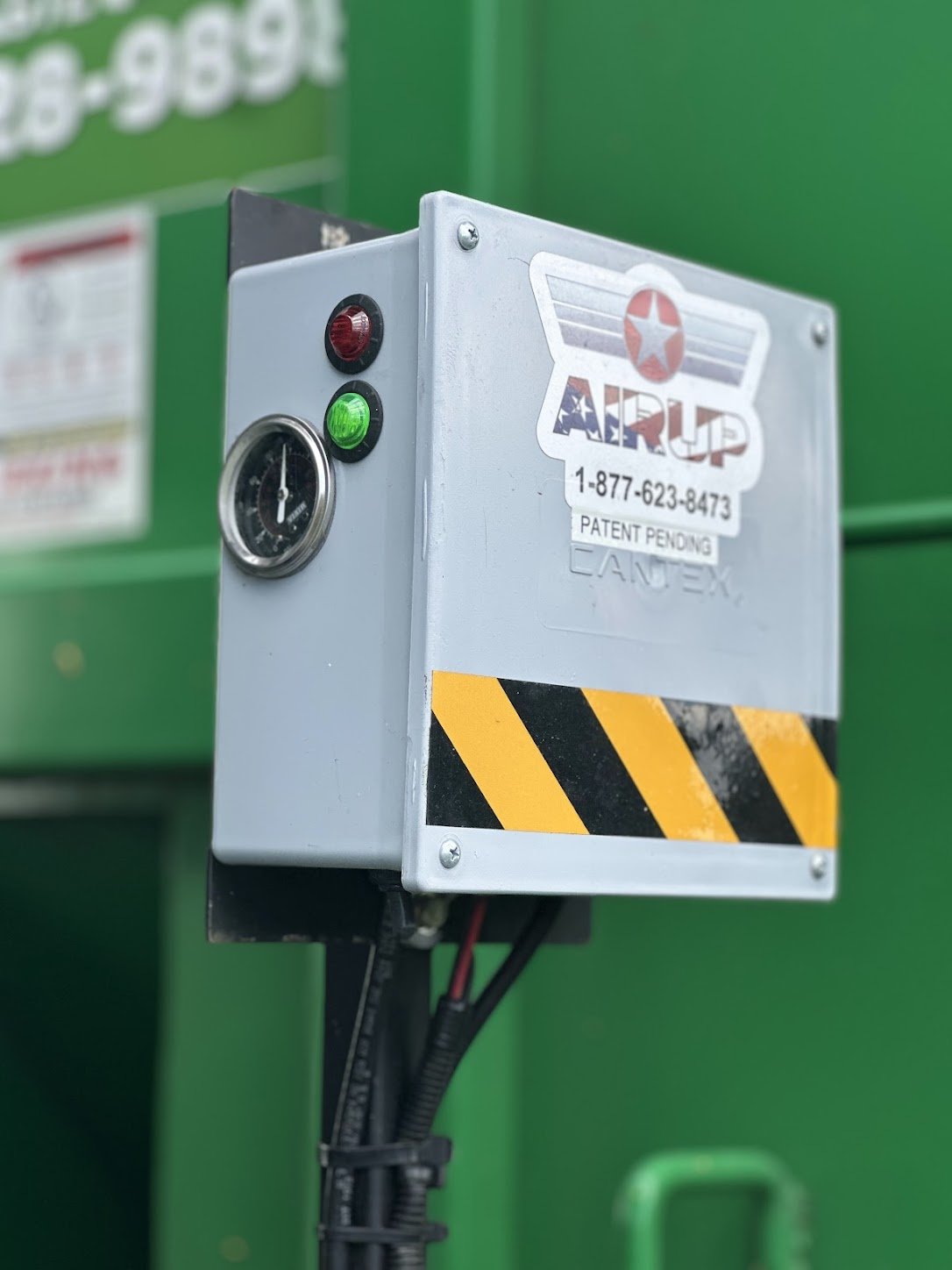 AirUp control box with pressure gauge and status lights mounted on a green truck body
